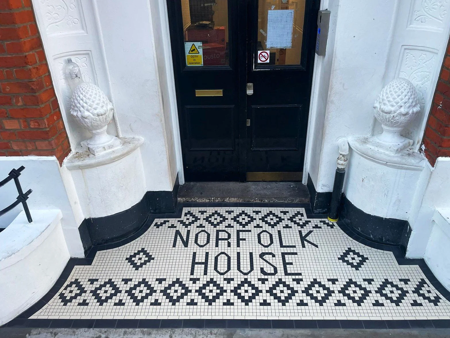 Wiktoriańska mozaika podłogowa z napisem Norfolk House przed wejściem do kamienicy w Londynie — projekt na wymiar firmy Martin Mosaic